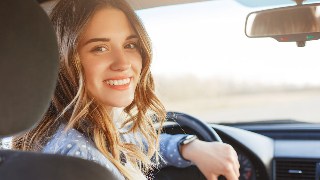 Jeune femme au volant d'une voiture